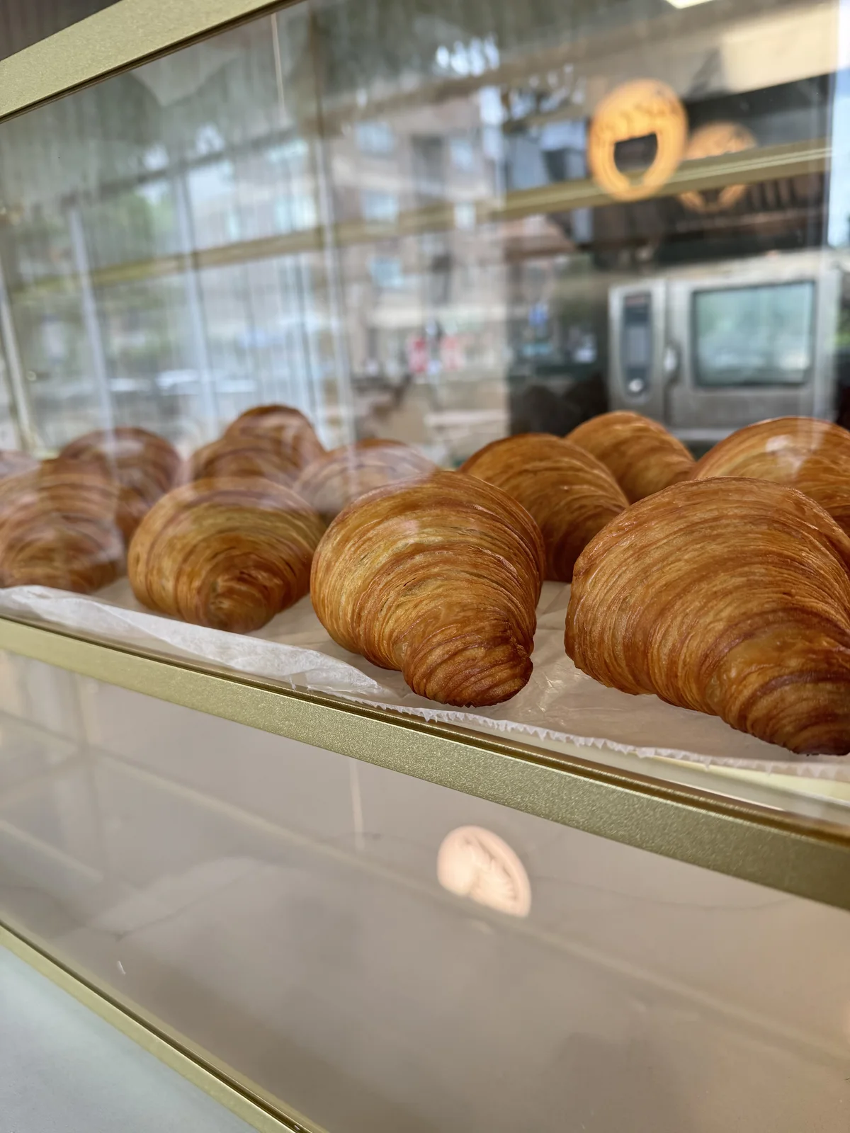 Golden croissants in the bakery display case at The Cake Pantry, Fishers